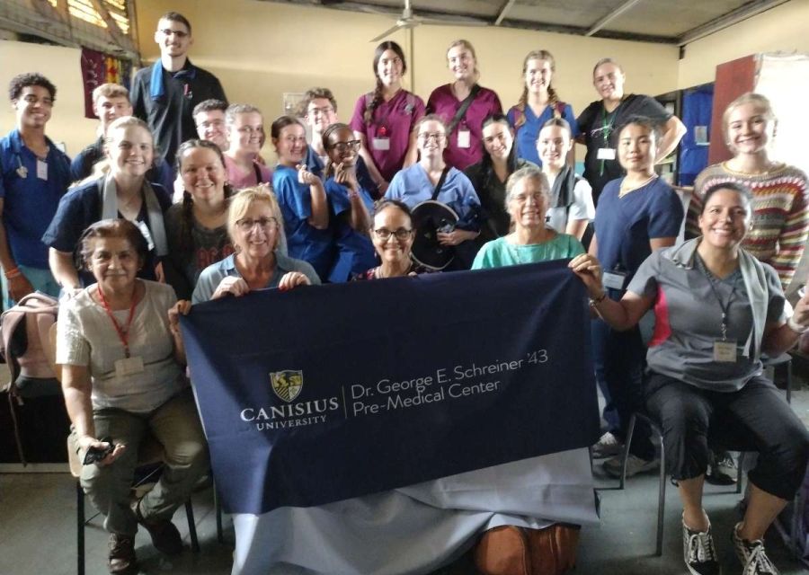 Group sitting with Canisius University Banner