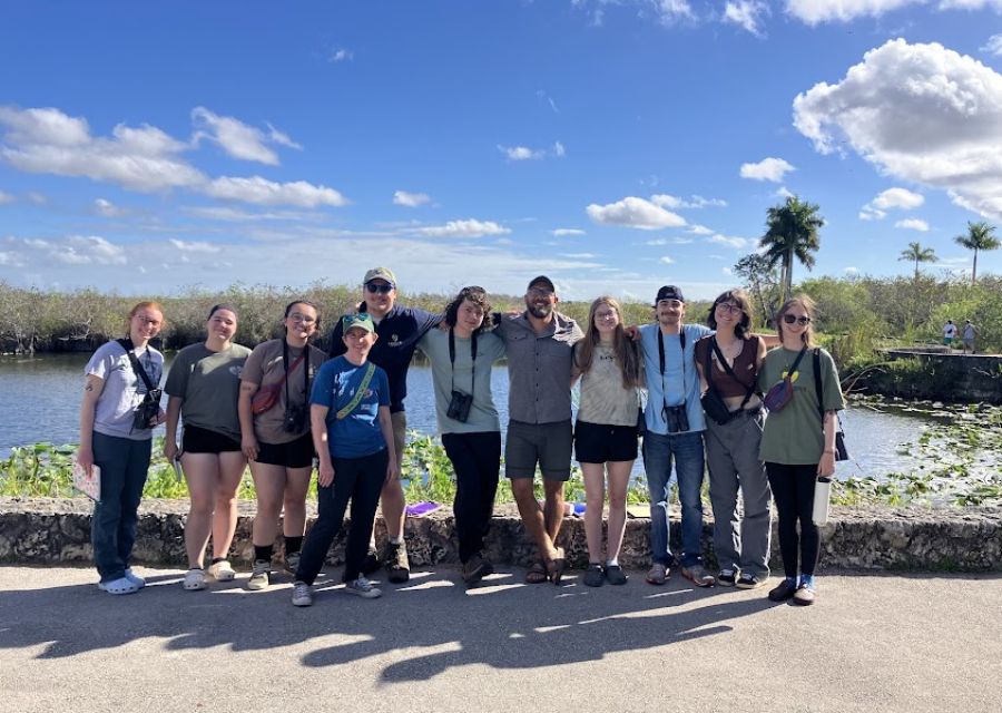 A group of people standing in front of water. 