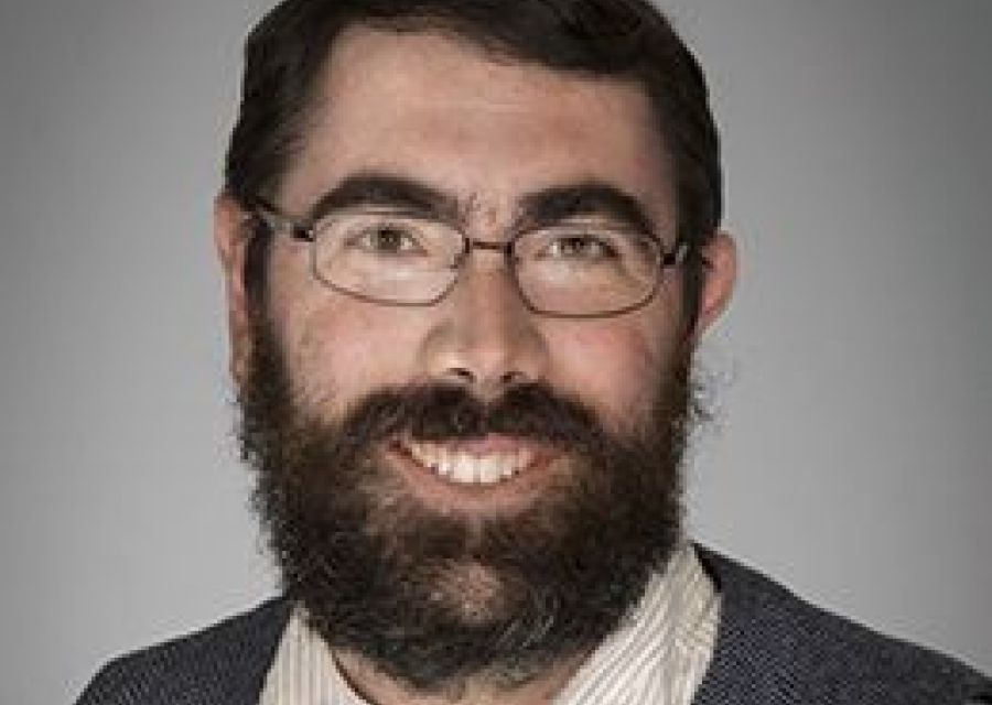 Photo of man with a beard wearing glasses. 