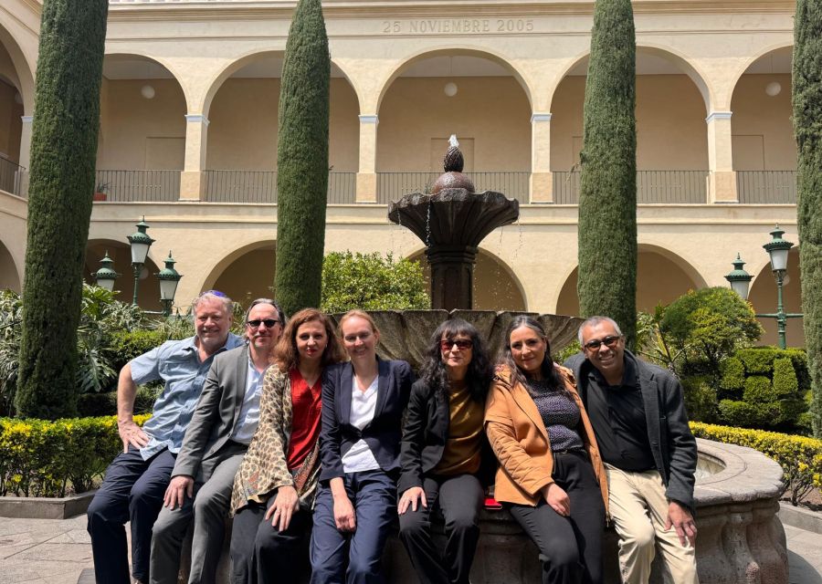 A group of people sitting in front of a fountain in Mexico. 