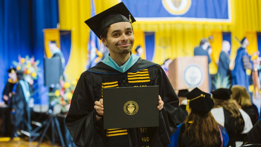 Photo of student receiving diploma at Commencement 2026 