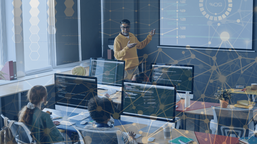 An instructor stands at the front of a computer lab. A transparent network pattern overlays the image