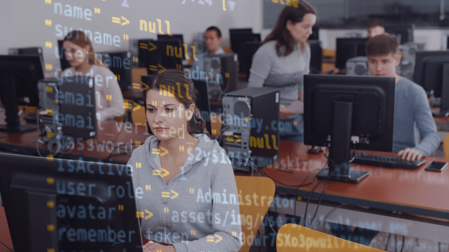 Students sit at computers in a classroom with a transparent overlay of programming code.