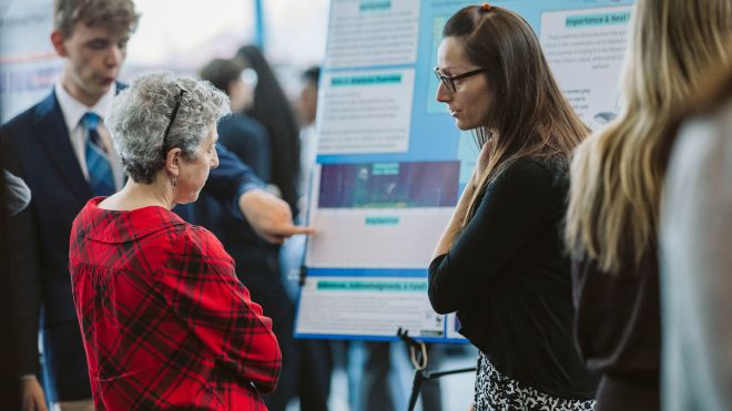 Two woman looking at a poster.