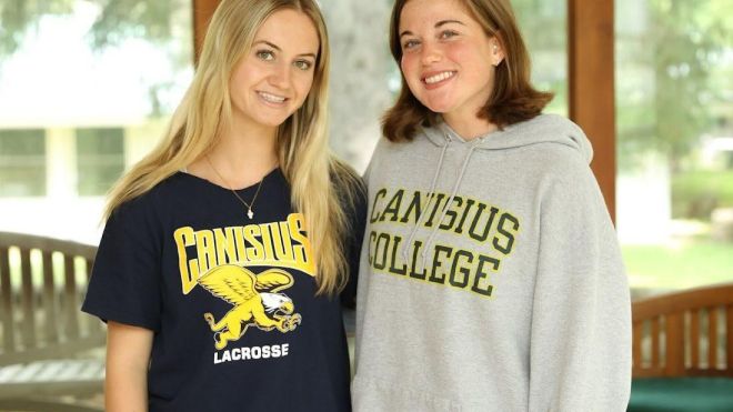 Two female students in Canisius University gear.