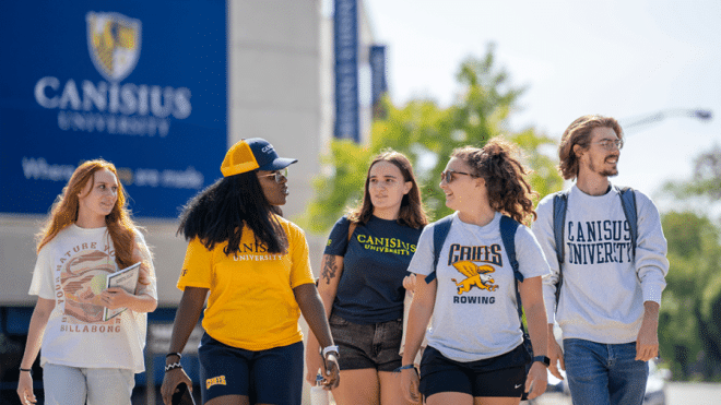 A group of Canisius students walking, talking down Main Street 