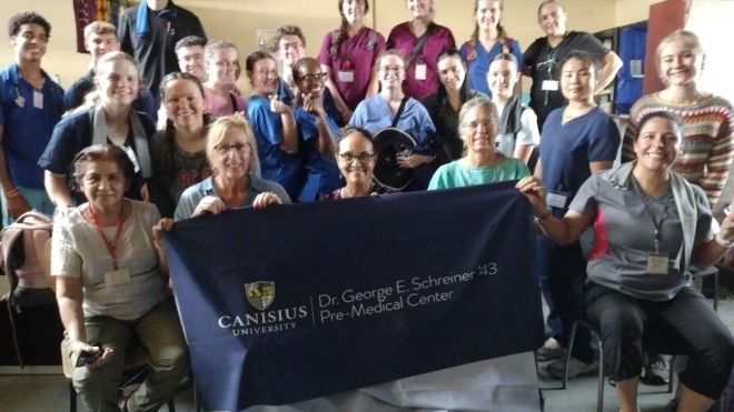 Group sitting with Canisius University Banner
