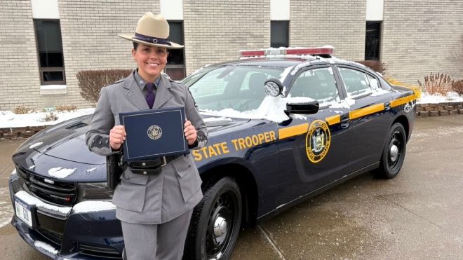 Jill Galanti stands in front of a New York State Trooper vehicle.