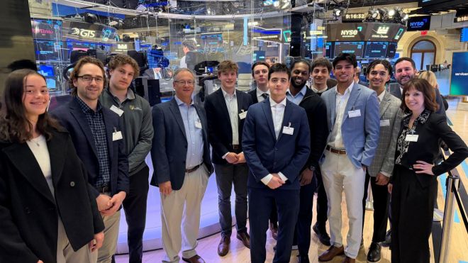 Students and faculty standing on floor of the New York Stock Exchange