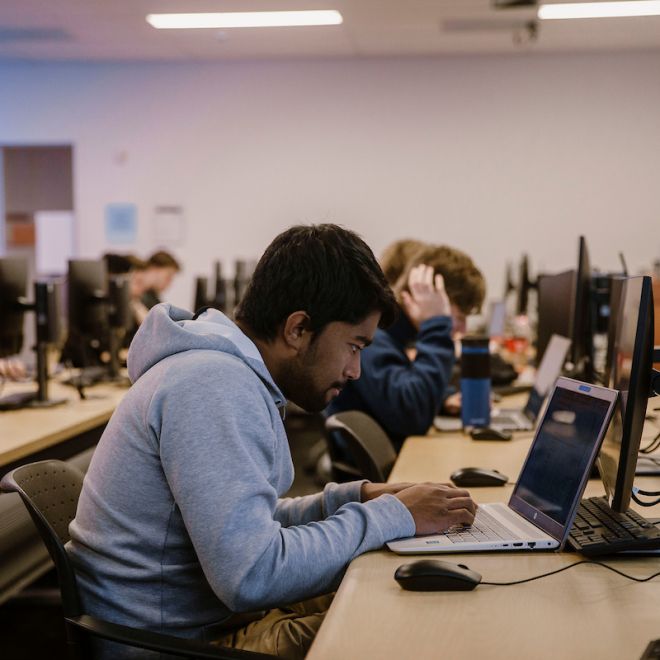 students in a computer lab working on a data project on computers