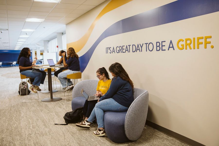 Student doing work at a shared table at a student success center