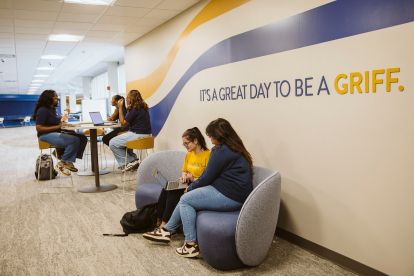 Student doing work at a shared table at a student success center