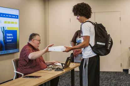 Canisius IT staff handed out laptops to students during New Griff orientation.