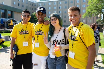 Students Gathered in the quad during a college welcome week, smiling and wearing similar yellow shirts