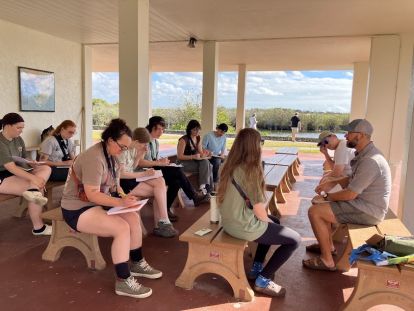 A group of people sitting on benches.