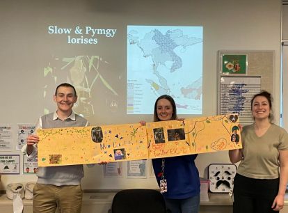 Three people holiding up a poster