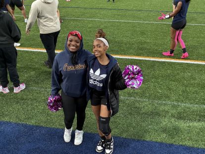 Kayla (left) and Kimorah cheer on their teammates.