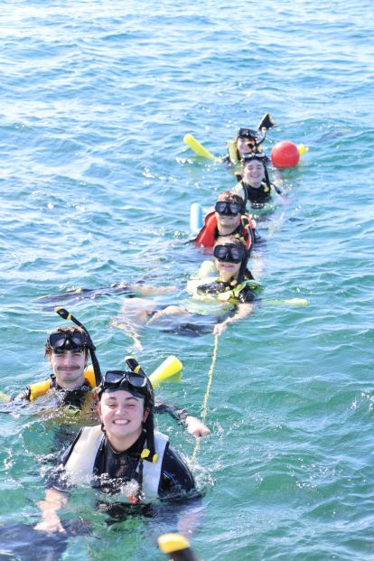 Students in the water snorkeling.