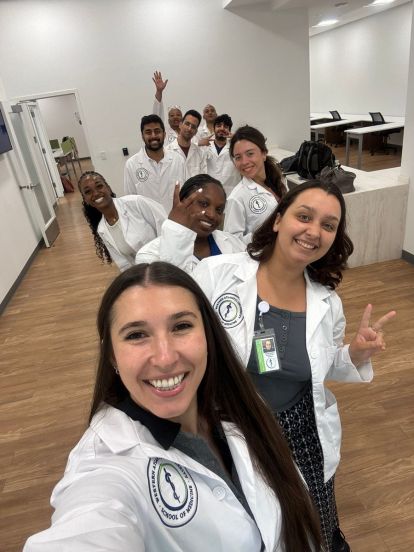 Students in the new six-year BS/MD pathway with Western Atlantic University School of Medicine pose for a photo, wearing their white coats